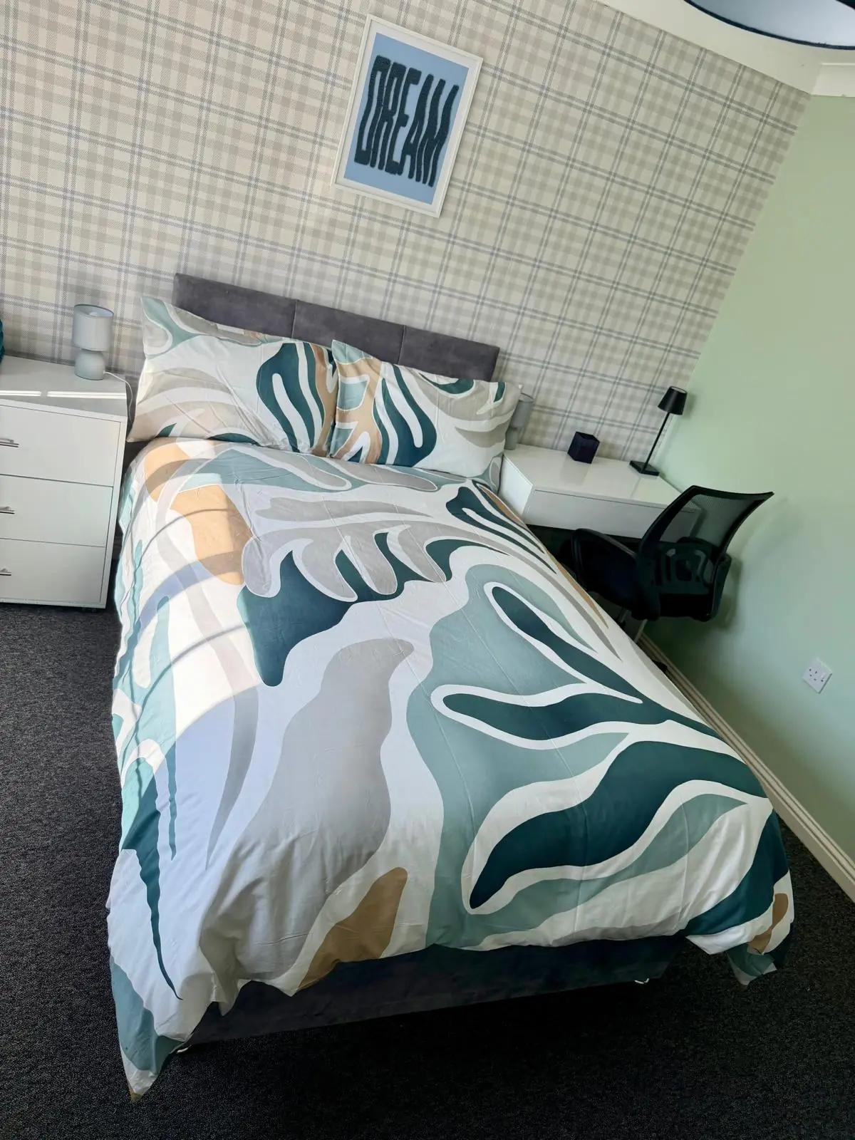 Bedroom with patterned bedding and desk area