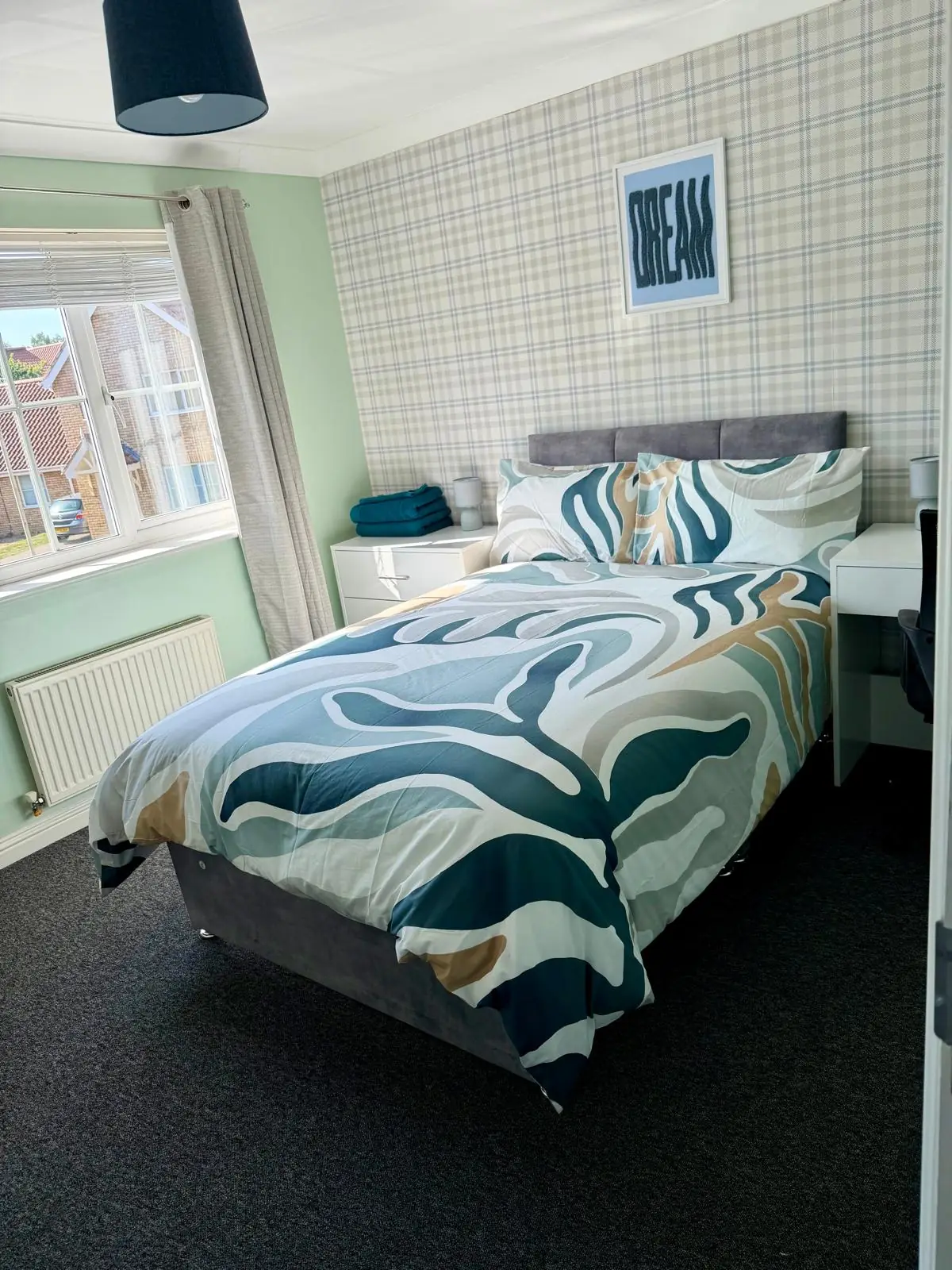 Bedroom with patterned bedding and front window