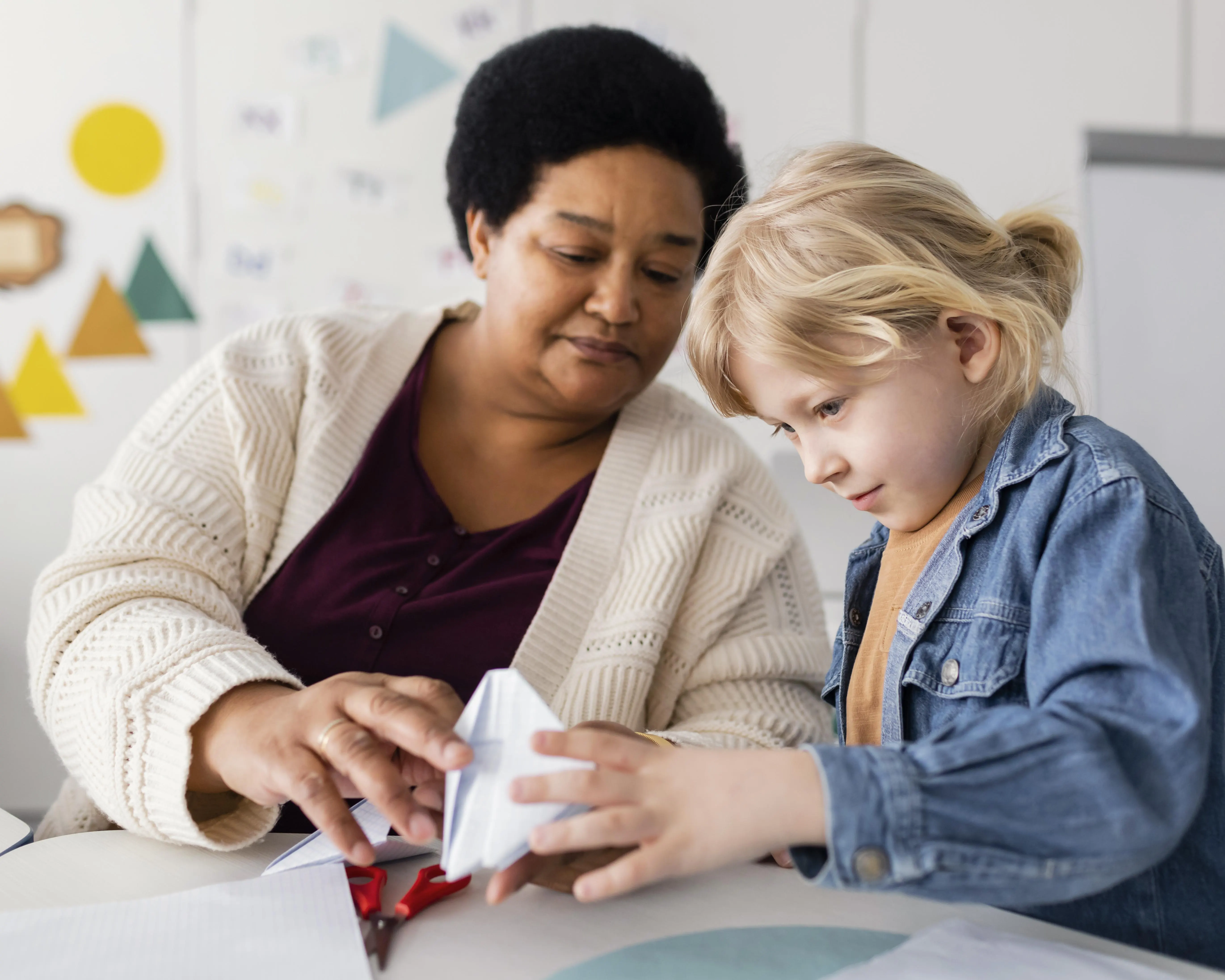 Adult supporting a child during a calm creative activity